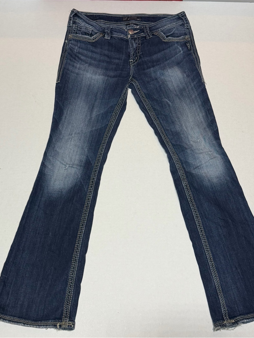 Silver Jeans Dark Blue Flare Jeans with Faded Whiskering and ornate metal accent